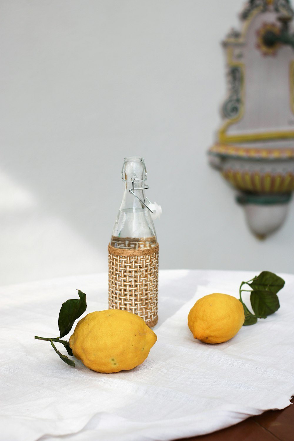 two lemons and a glass bottle on a table