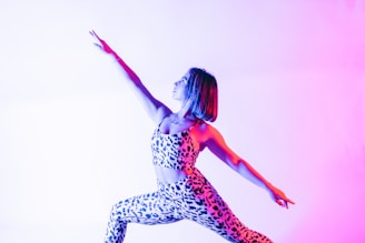 a woman in a leotard jumpsuit doing a yoga pose