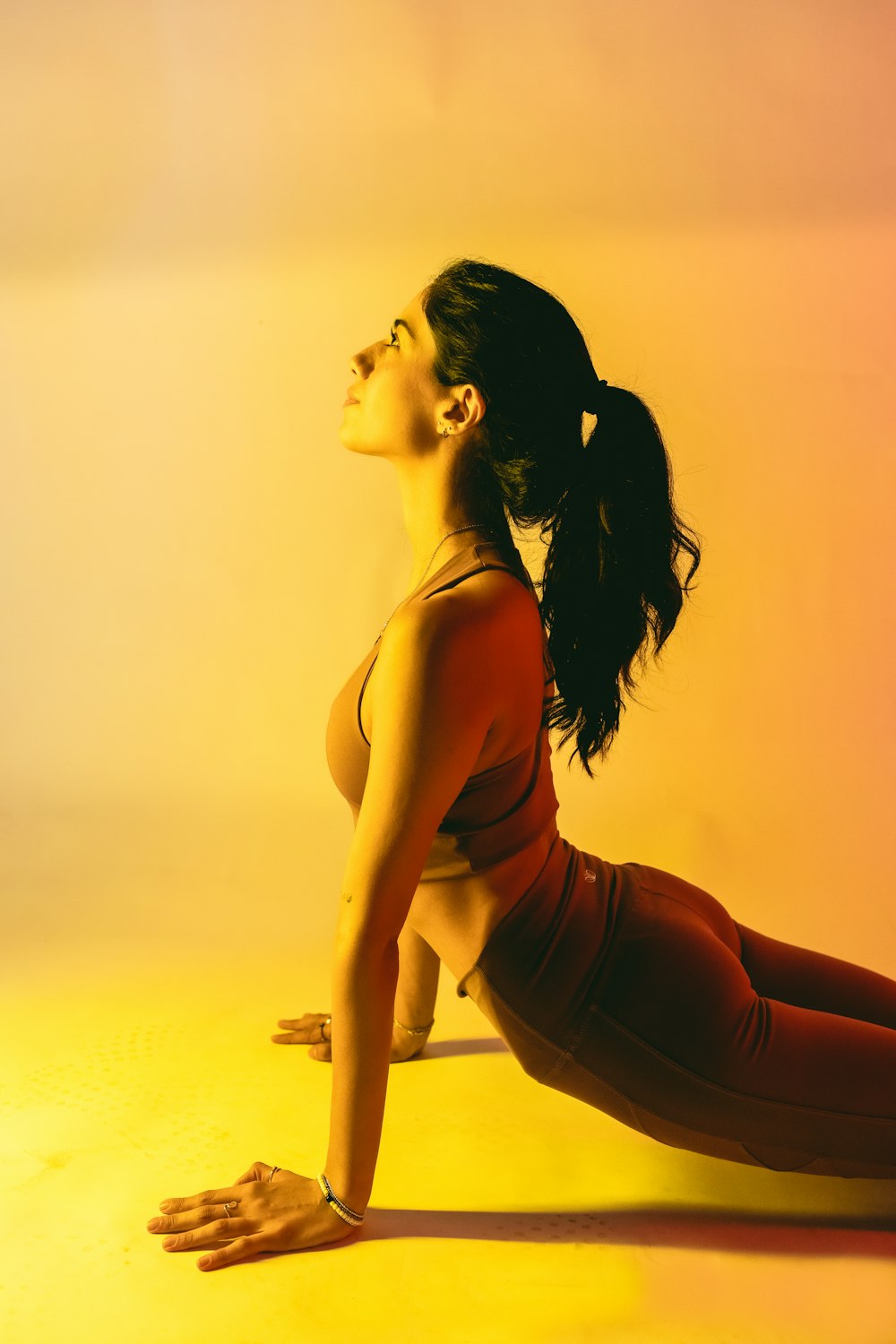 Eine Frau in einem roten Oberteil macht eine Yoga-Pose