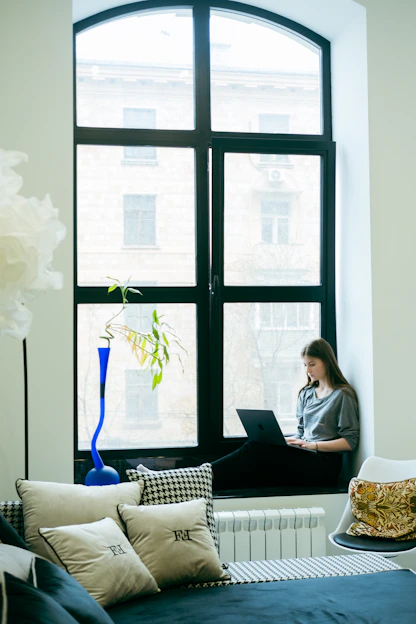 a woman sitting on a couch using a laptop computer