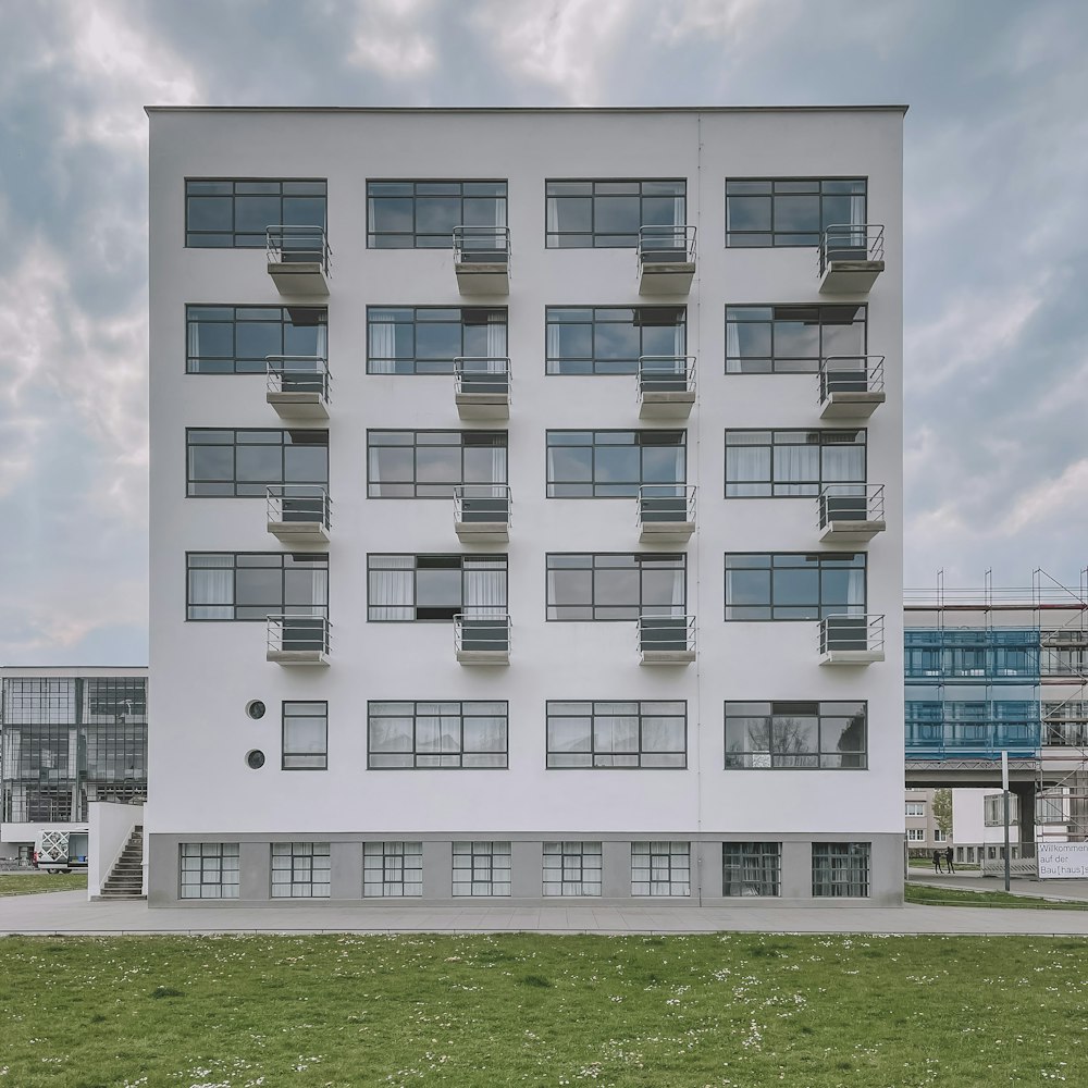 a tall white building with balconies and windows