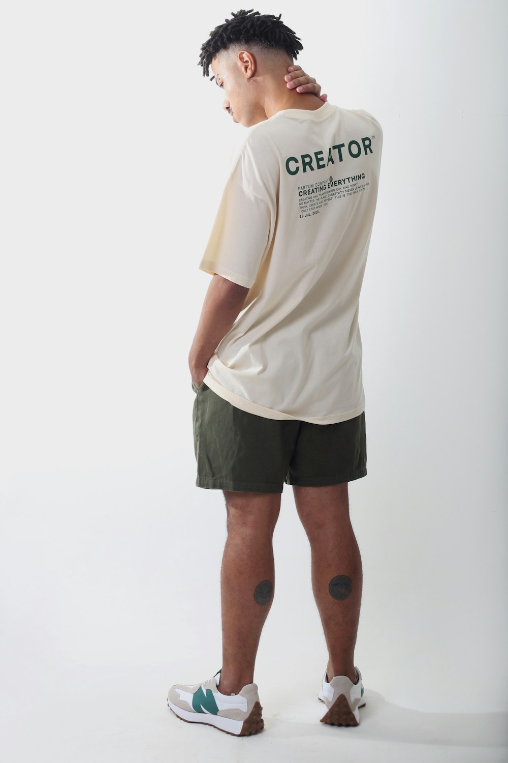 a man in a white shirt and green shorts