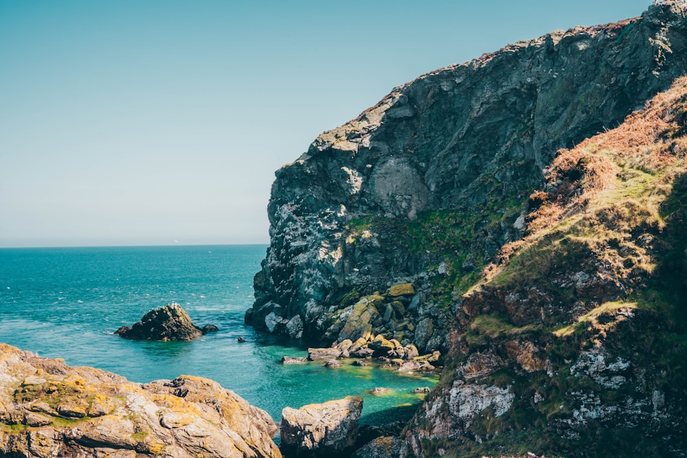 a body of water near a rocky cliff