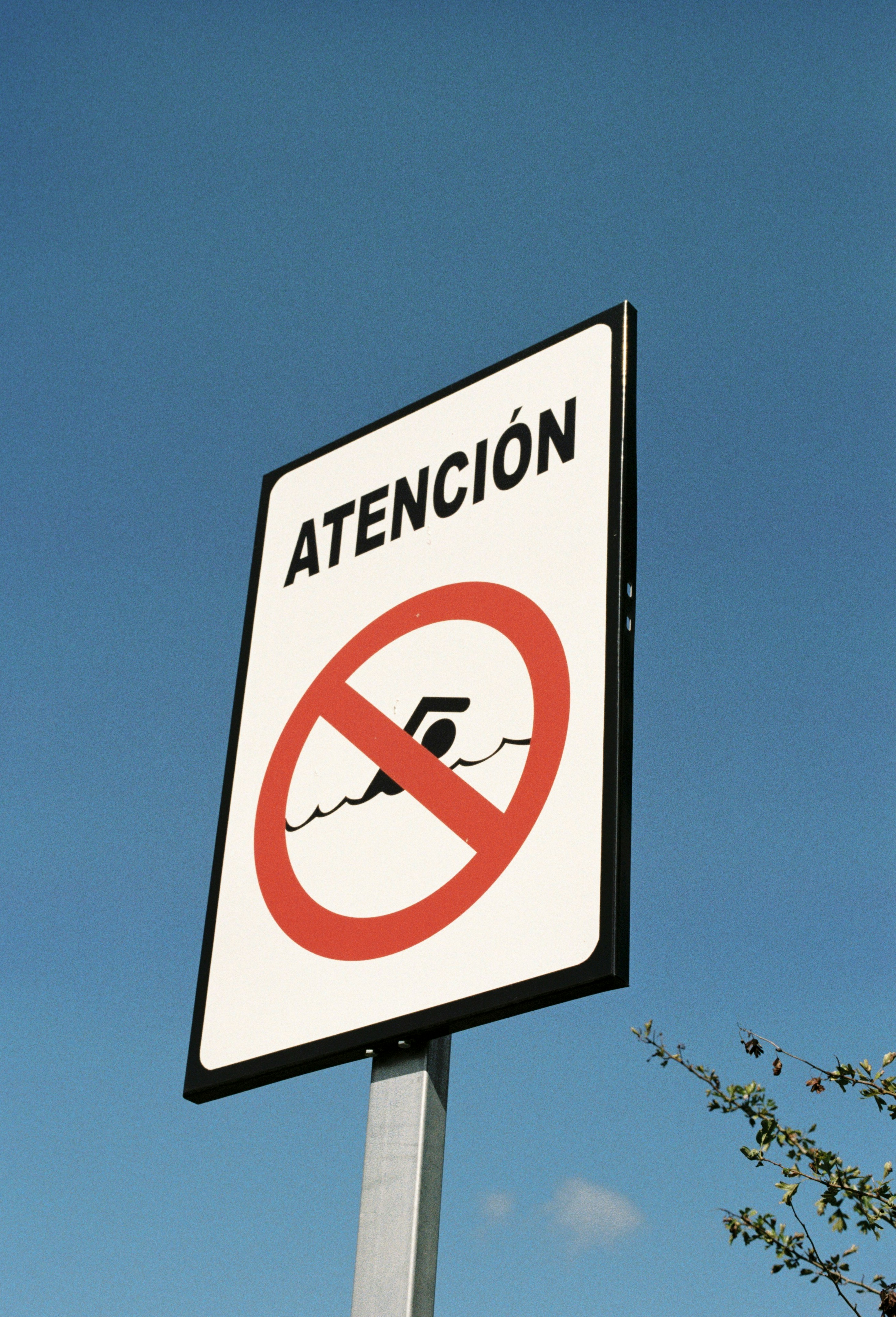 a street sign with a picture of a man swimming in a pool