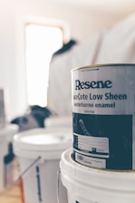 a can of paint sitting on top of a white bucket