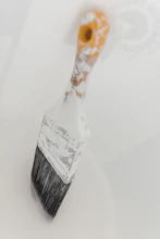 a close up of a paint brush on a white surface