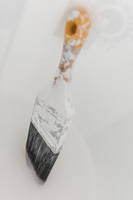 a close up of a paint brush on a white surface
