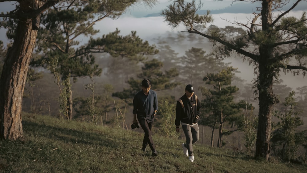 two people walking up a hill in the woods