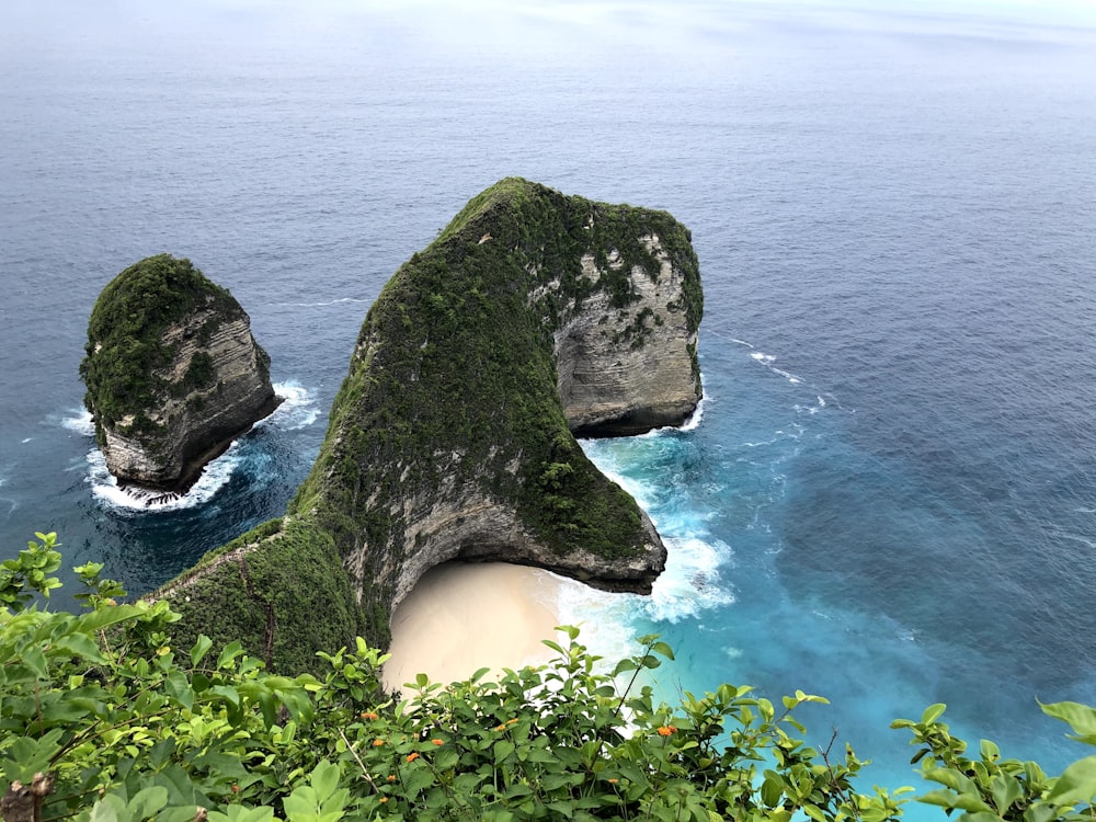 a couple of large rocks sticking out of the ocean