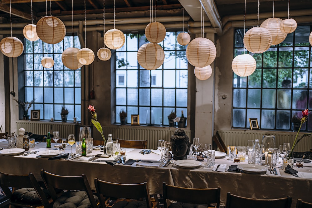 a long table with a bunch of paper lanterns hanging from the ceiling