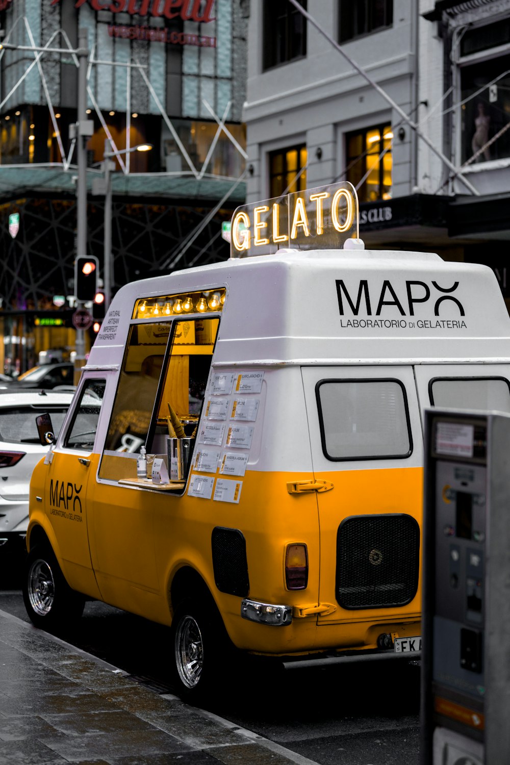 a yellow and white food truck parked on the side of the road