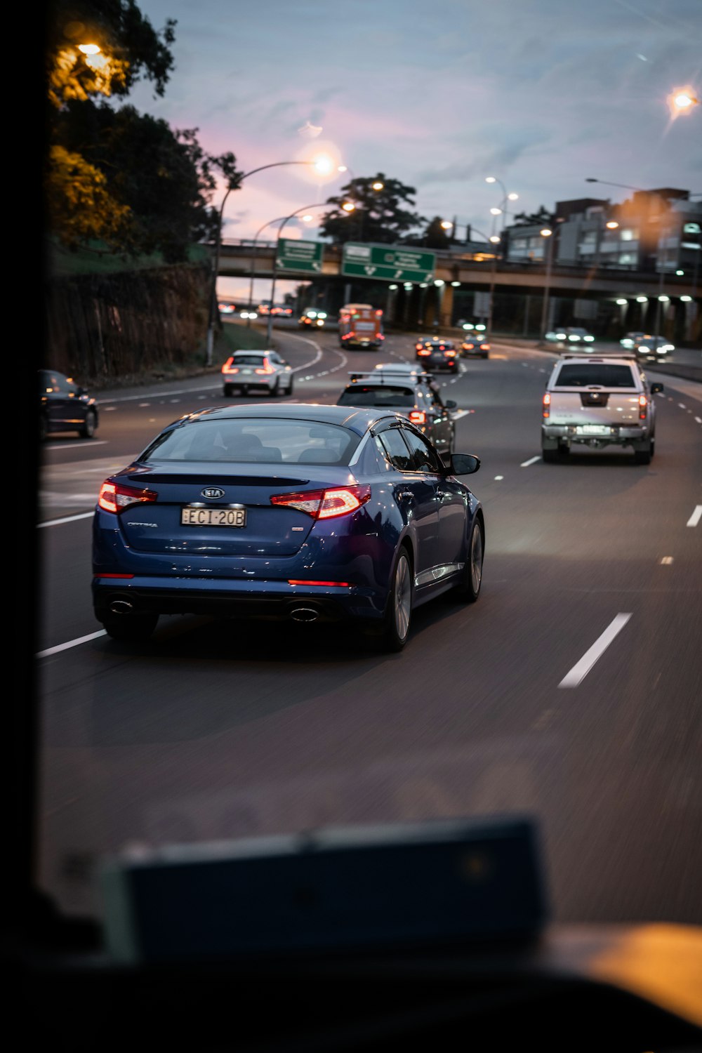 a blue car driving down a street at night