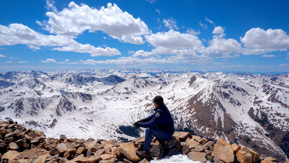 a person sitting on top of a rocky mountain