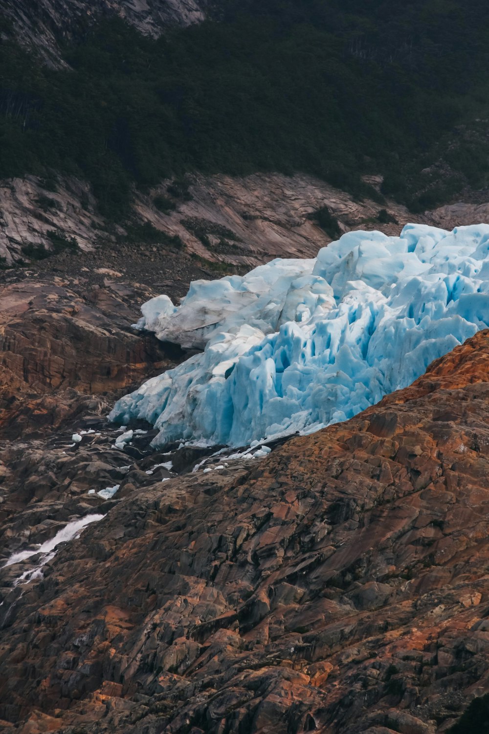 a large blue iceberg sitting on the side of a mountain