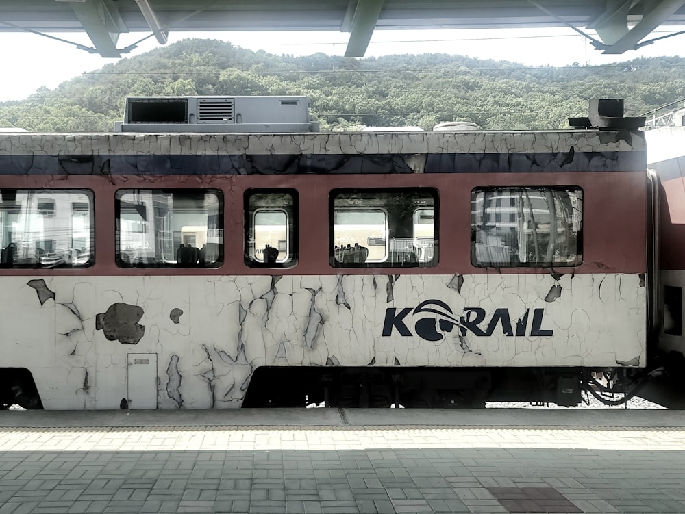 a red and white train car sitting on top of a train track