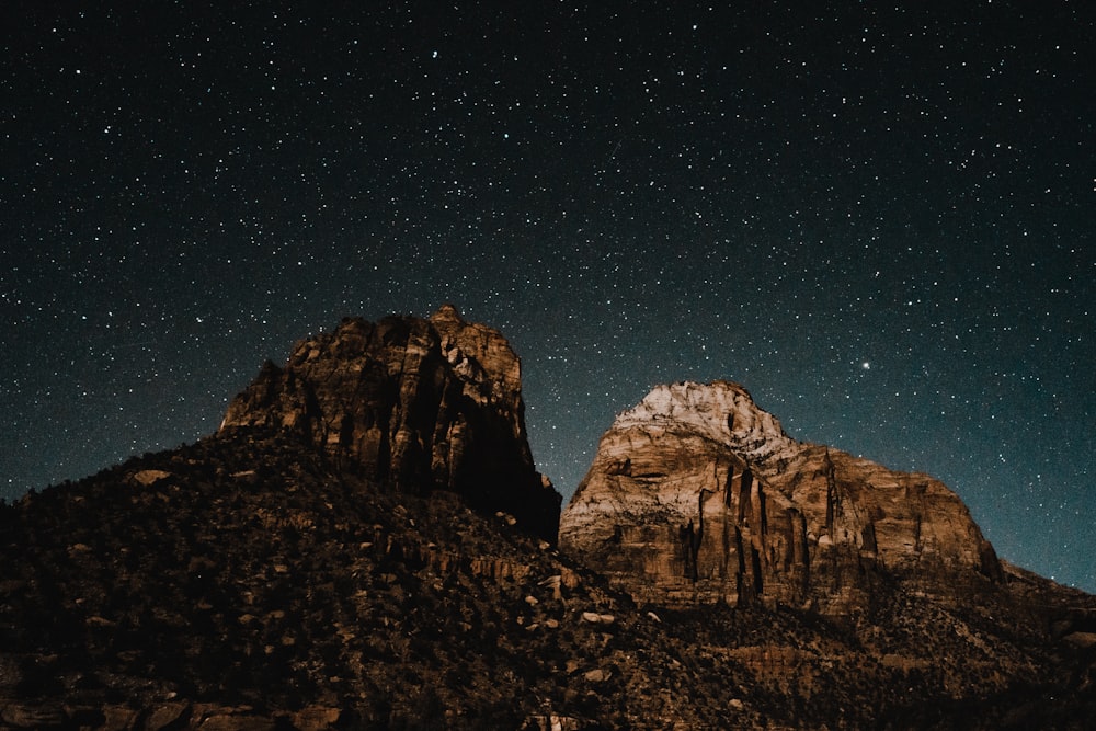 the stars shine brightly above the mountains at night