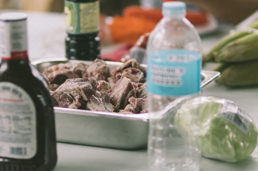 a metal pan filled with meat sitting on top of a table