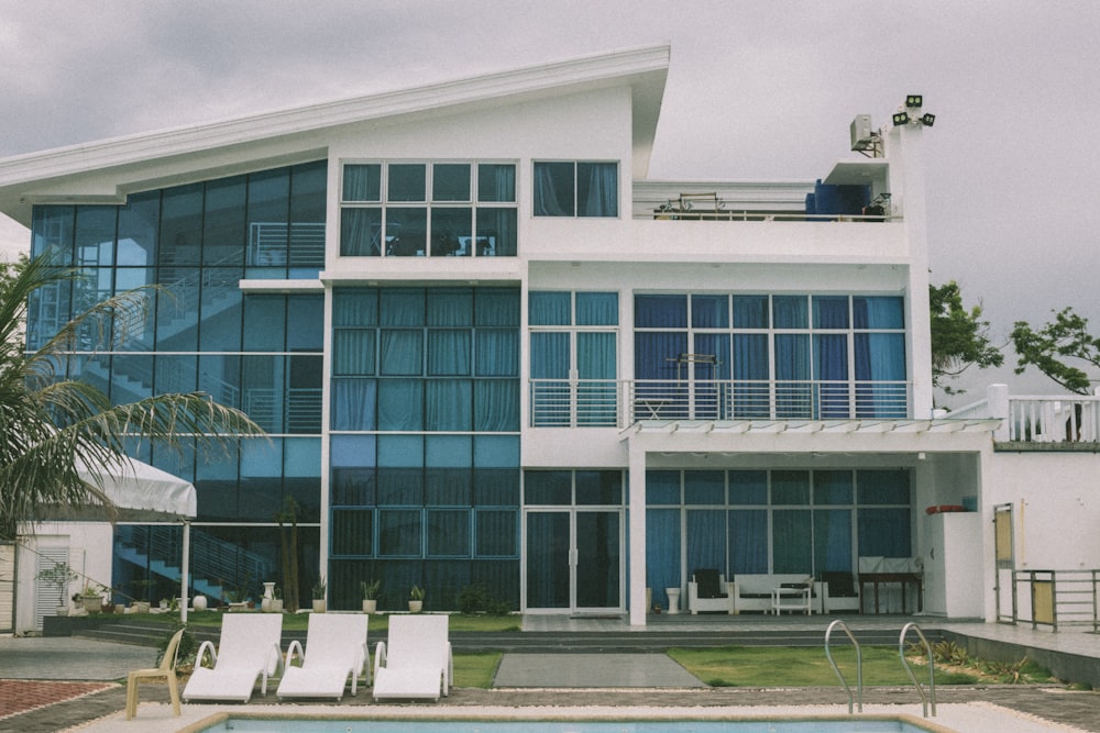 a large white house with a pool in front of it