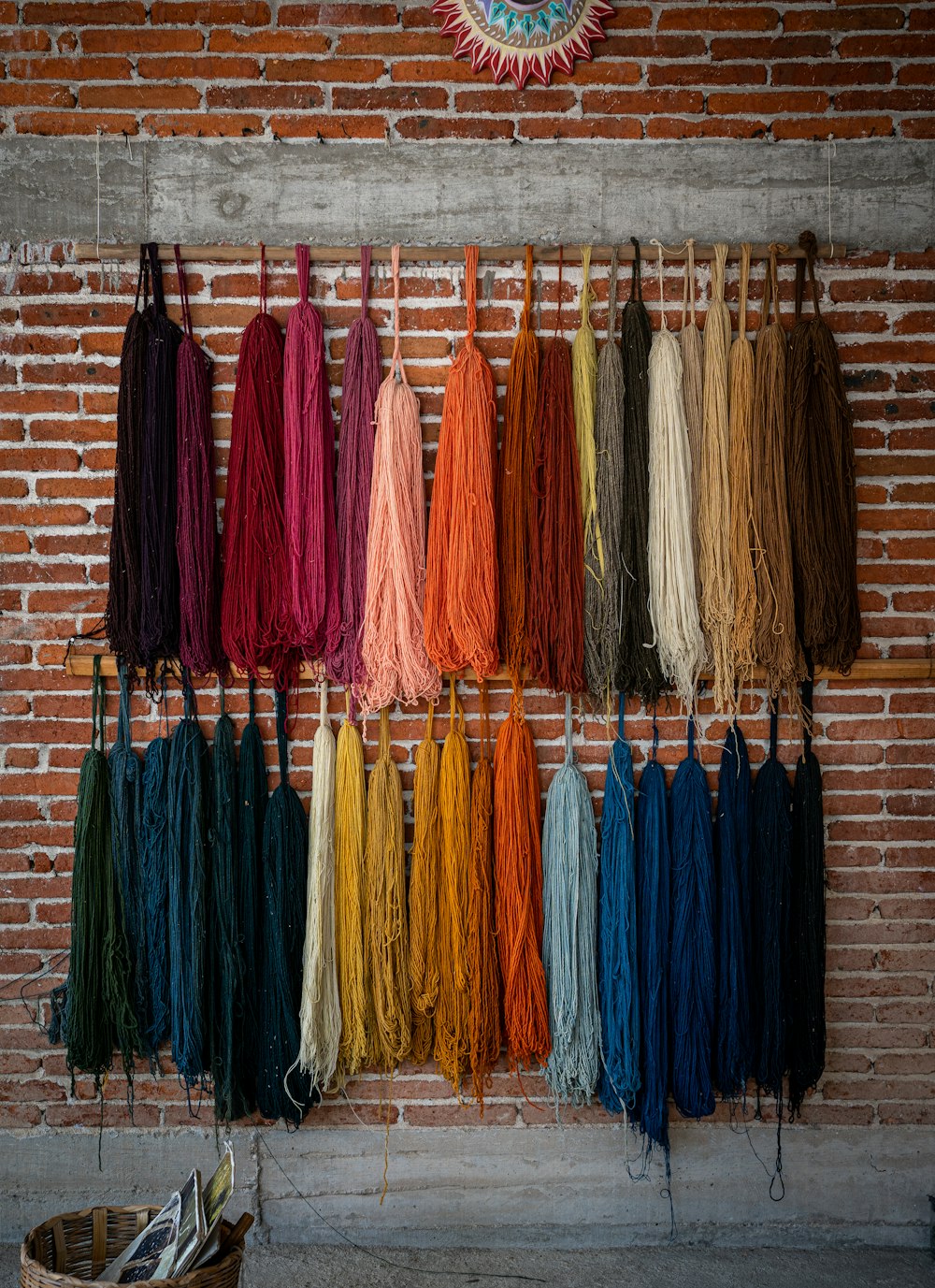 a bunch of yarn hanging on a brick wall