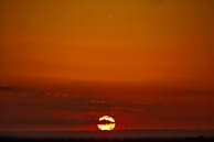 A golden-hued sunset behind wind turbines, reflecting the blend of technology and nature.