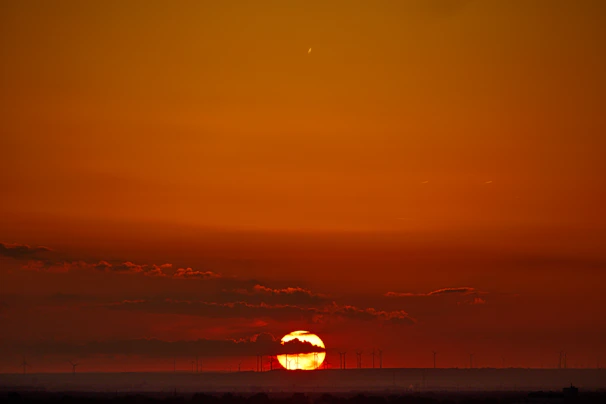 A vibrant sunset behind a solar farm, highlighting the harmony of nature and technology.