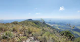 Scenic mountain landscape in Oaxaca with cacao trees under vibrant blue sky.