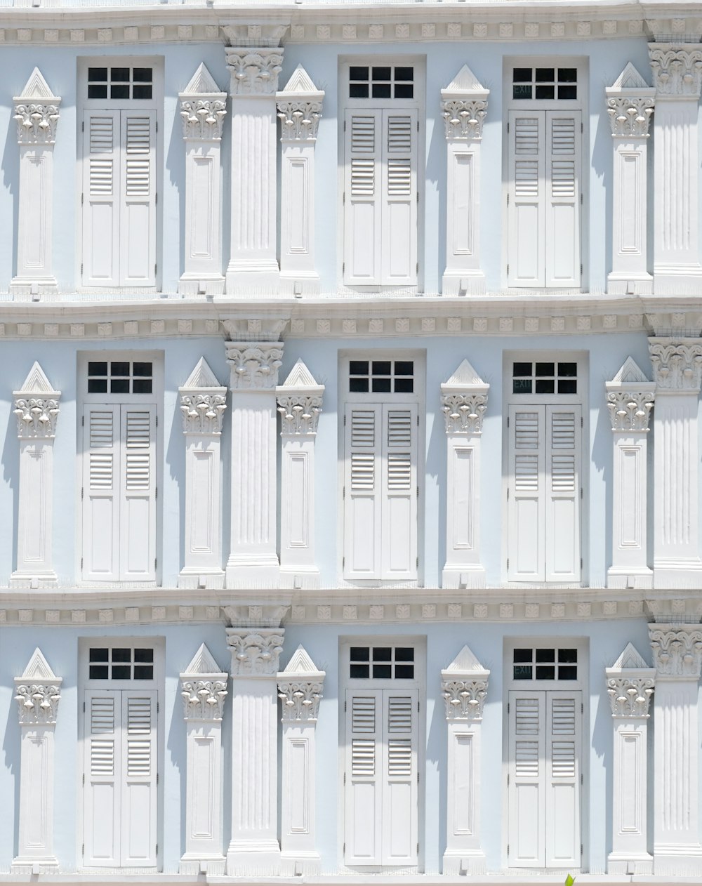a white building with many windows and shutters