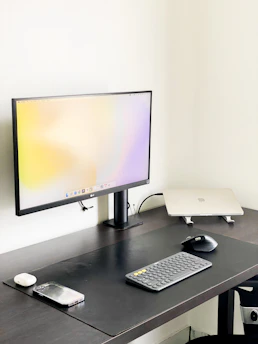 A minimalist workspace featuring a large monitor displaying dynamic marketing analytics with smooth animations.