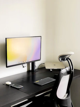 A sleek black and white workspace featuring minimalist design elements and a monochrome computer screen.
