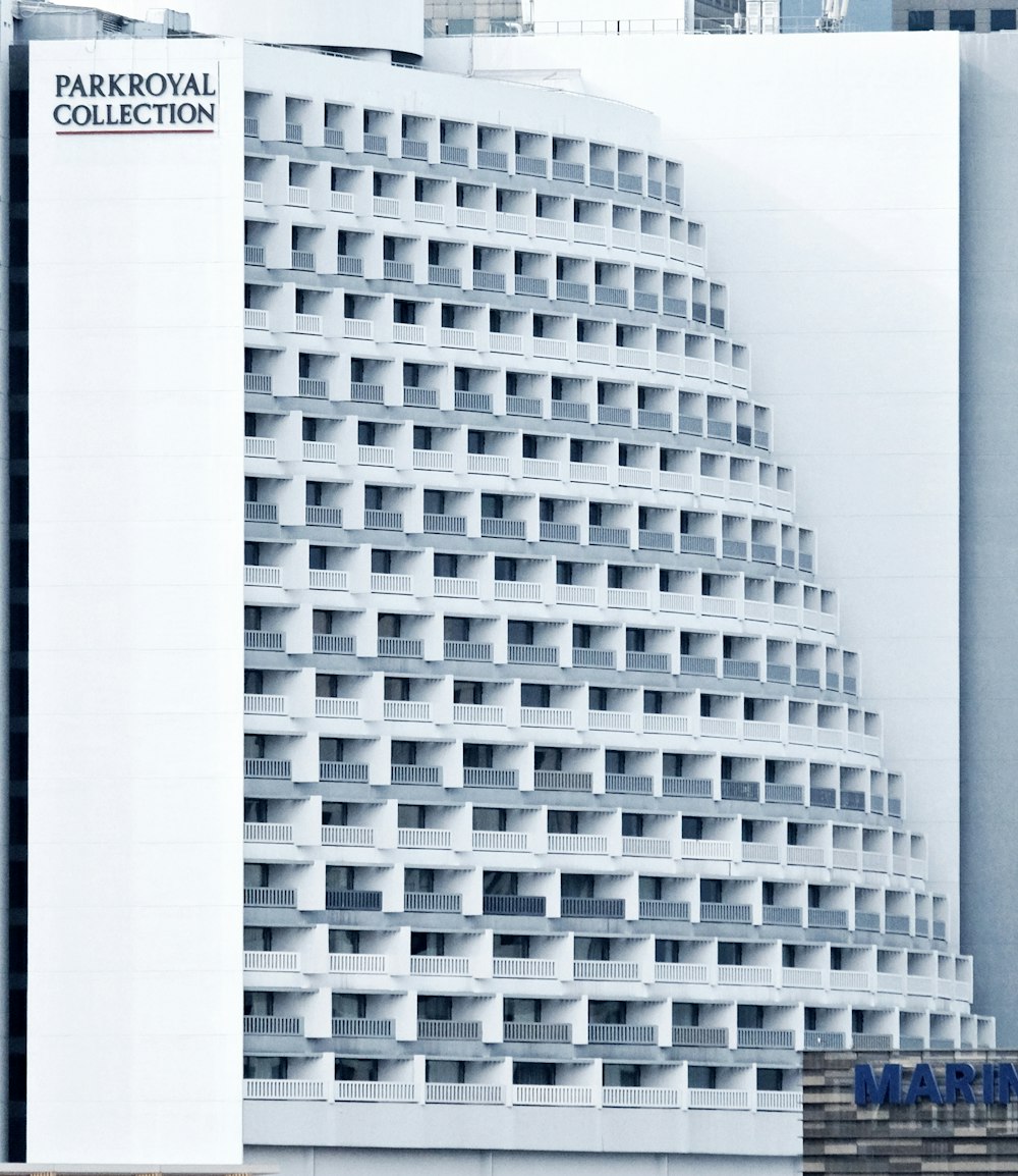 a tall white building with balconies in front of it