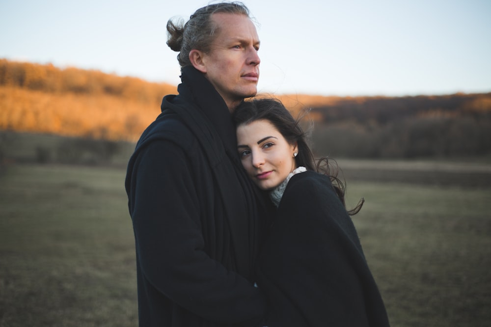 a man and a woman standing in a field