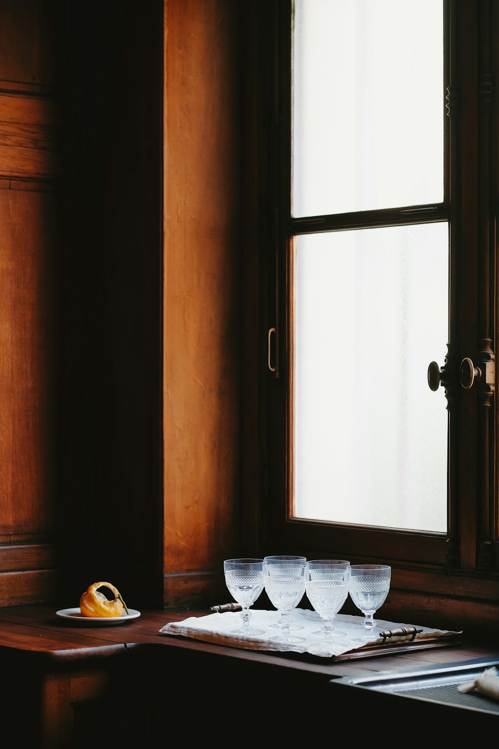 a table topped with glasses and a plate of fruit