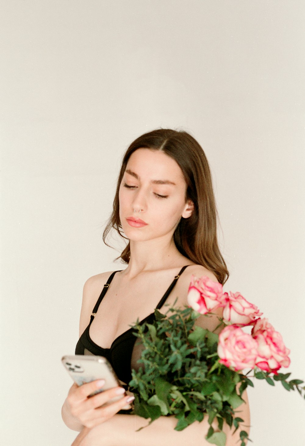 a woman holding a bouquet of flowers and a cell phone
