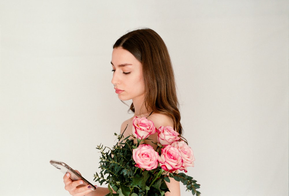 a woman holding a bouquet of flowers and a cell phone