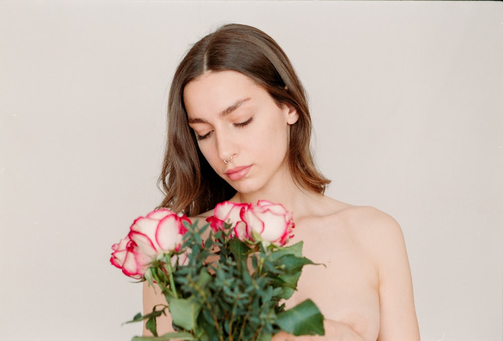 a naked woman holding a bouquet of roses