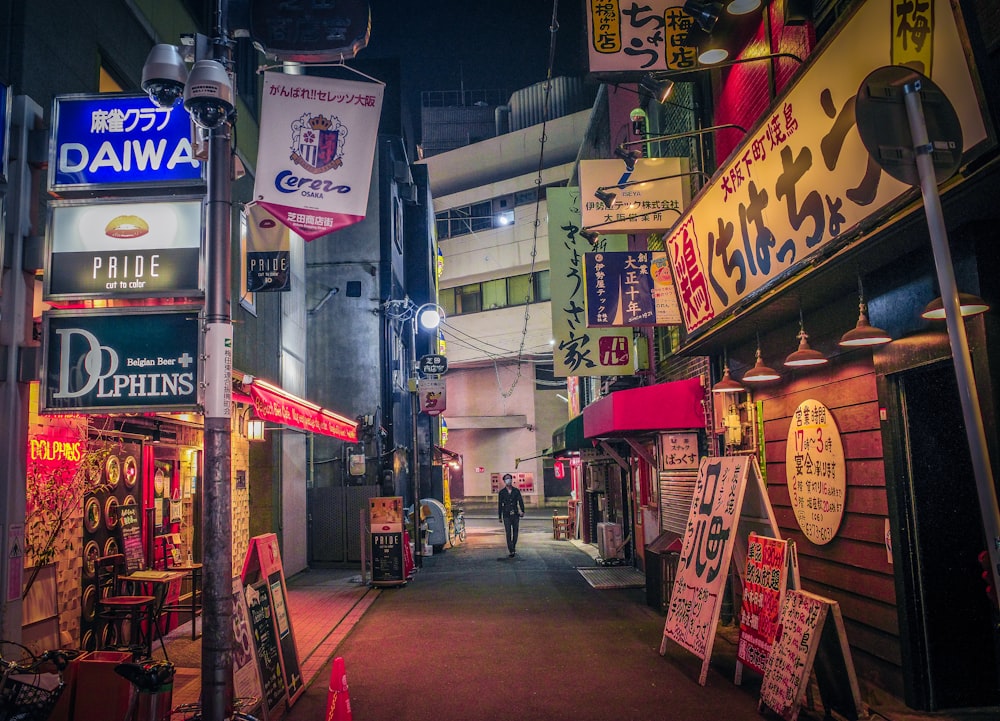 a narrow alley way with signs on the buildings