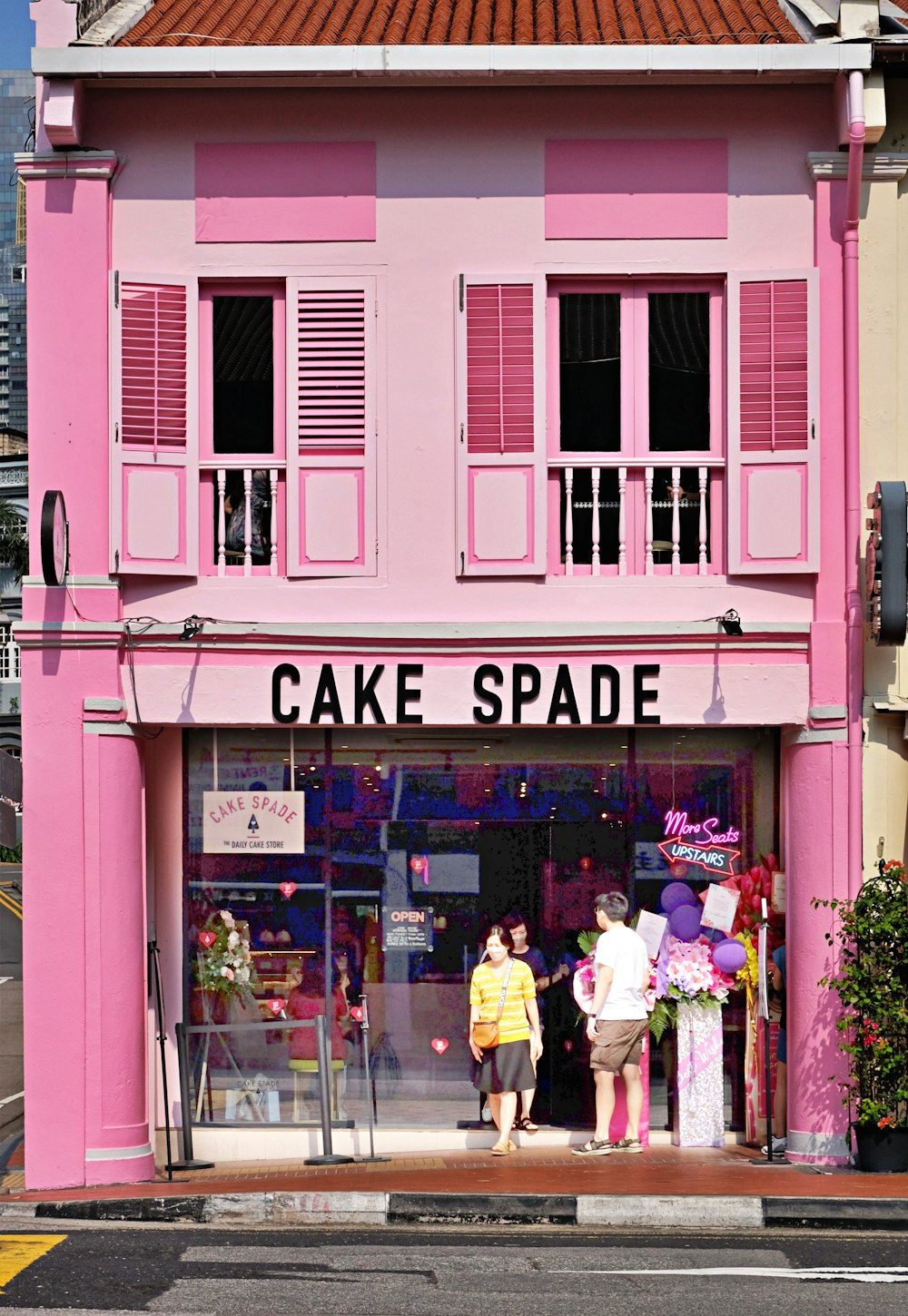 a pink building with people standing in front of it