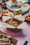 a table topped with boxes of food and drinks