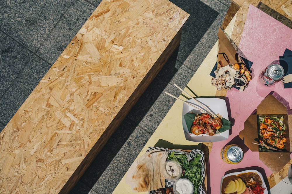 a table topped with plates of food next to a wooden table