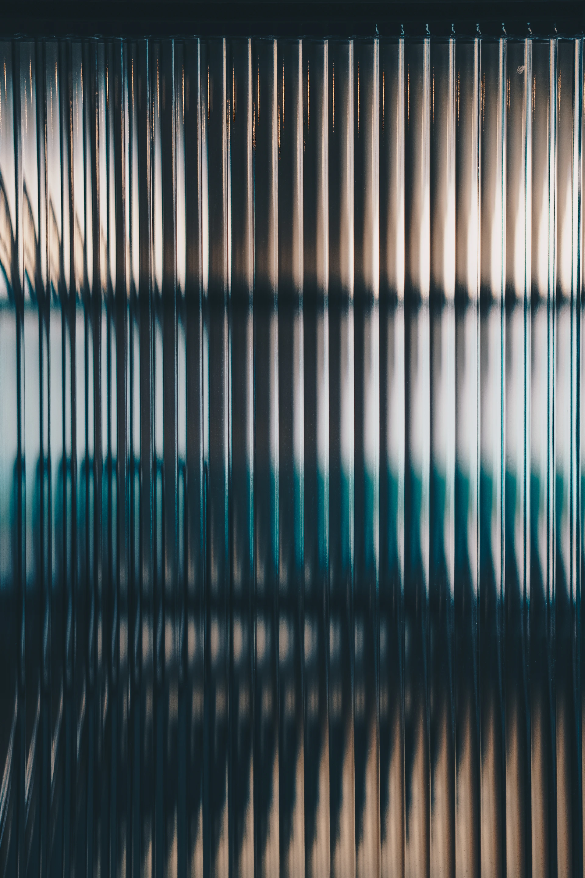 Vertical fluted glass texture with soft light and dark shadows