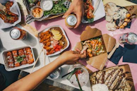 A joyful moment of sharing food among friends around a table filled with Afro-Creole dishes.