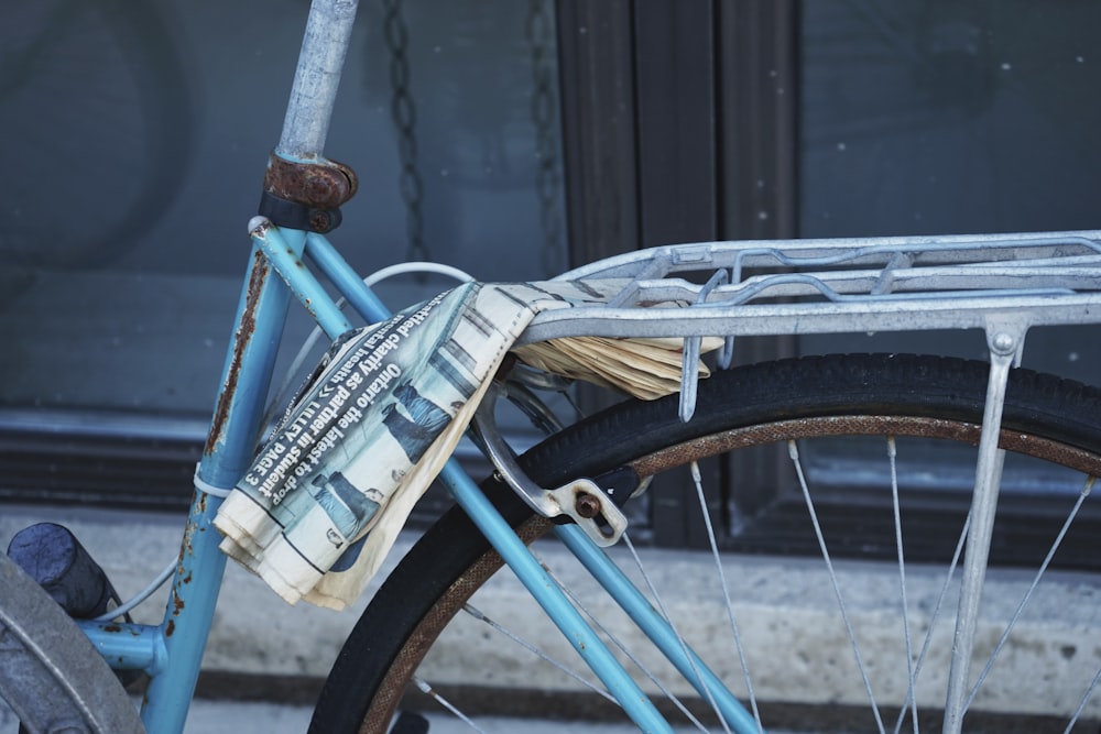 a blue bike with a newspaper on the back of it