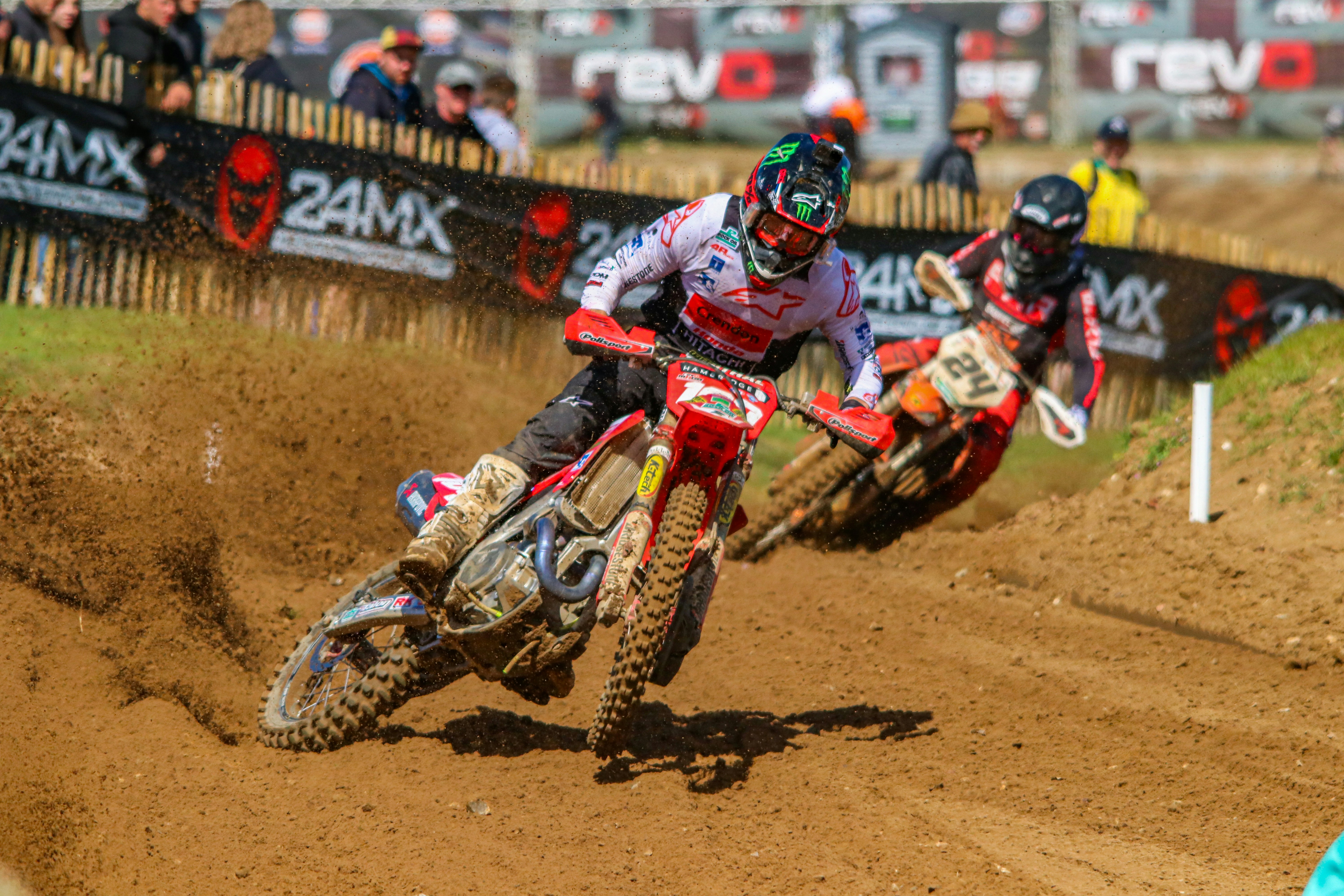 a group of people riding dirt bikes on a dirt track