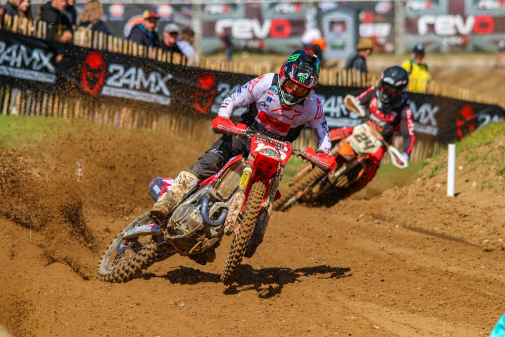 a group of people riding dirt bikes on a dirt track