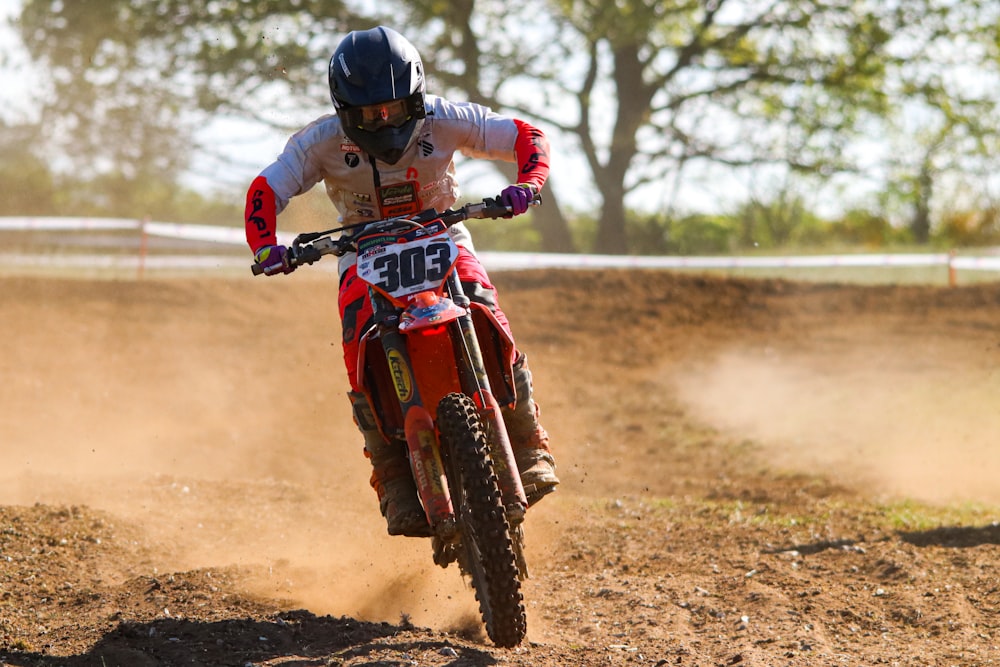 a man riding a dirt bike on top of a dirt field