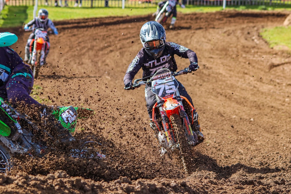 a group of people riding dirt bikes on a dirt track