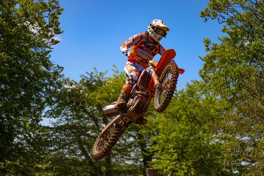 a man riding a dirt bike through the air