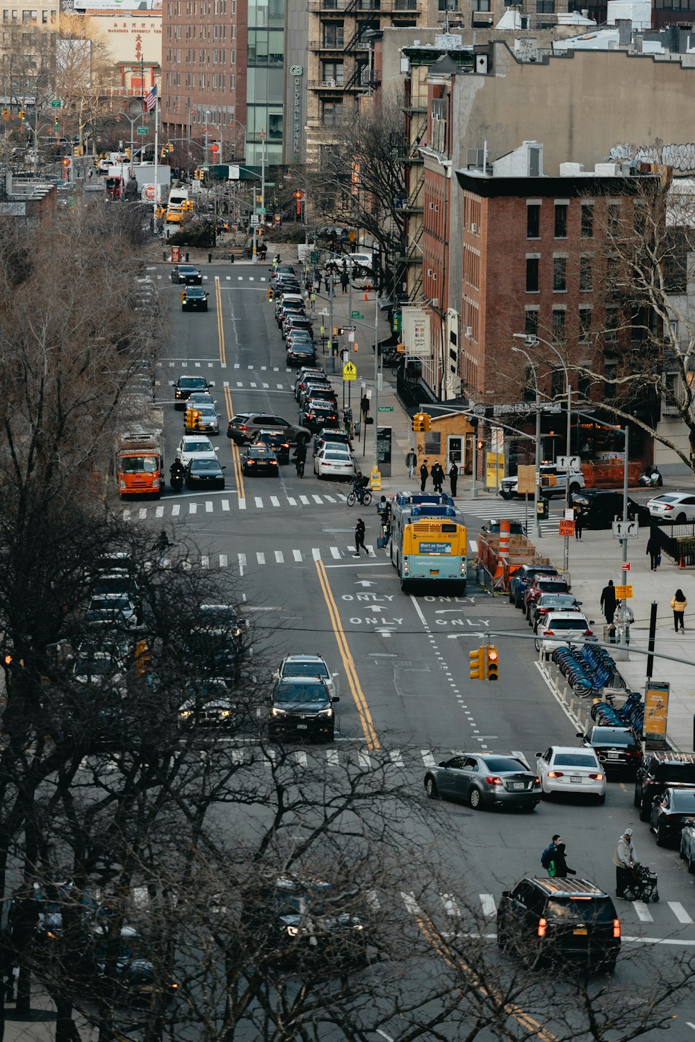 a city street filled with lots of traffic next to tall buildings