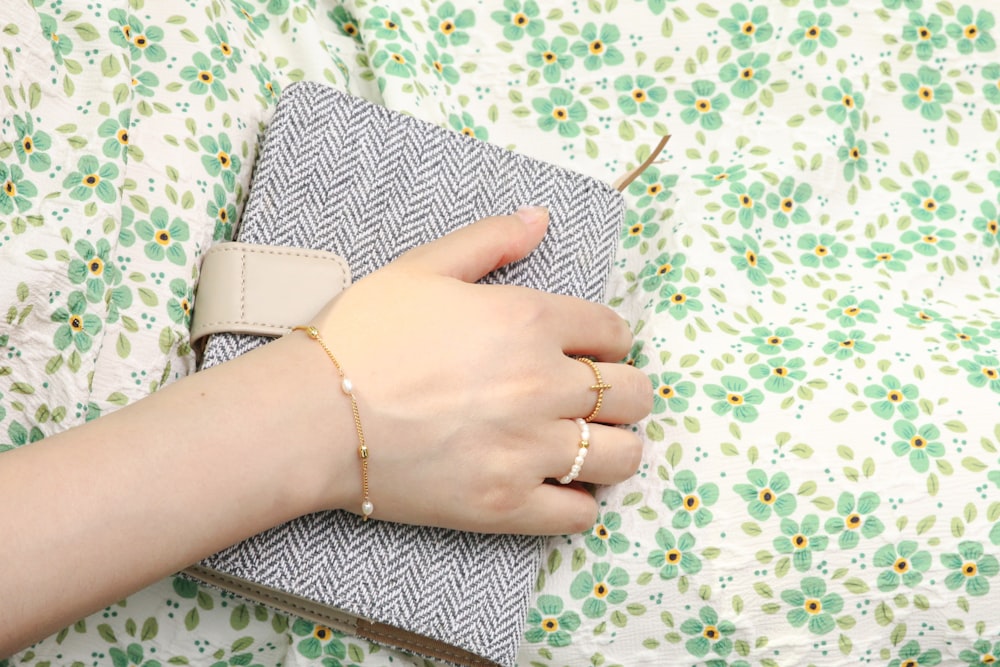 a woman's hand is holding a small notebook