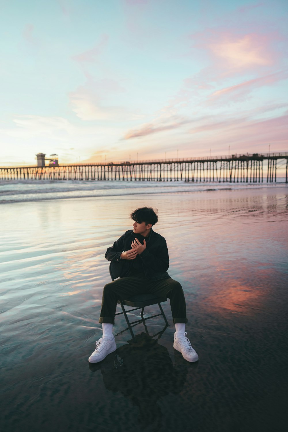 a person sitting on a chair on the beach